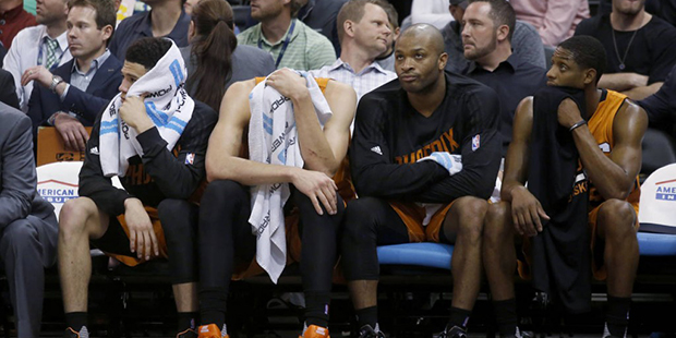 Phoenix Suns' Devin Booker, Alex Len, P. J. Tucker, and Brandon Knight, from left, sit on the bench...