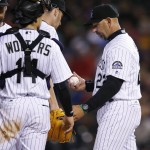 Colorado Rockies manager Walt Weiss, right, takes the ball from starting pitcher Chris Rusin, back left, as catcher Tony Wolters looks on as Rusin is pulled from the mound after giving up an RBI-single to Arizona Diamondbacks' Jean Segura in the sixth inning of a baseball game Tuesday, May 10, 2016, in Denver. (AP Photo/David Zalubowski)