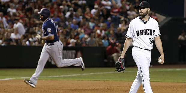 Arizona Diamondbacks' Robbie Ray (38) walks back to the mound with a new baseball after giving up a...