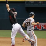San Francisco Giants' Kelby Tomlinson (37) reaches first base safely as Arizona Diamondbacks' Paul Goldschmidt, left, is pulled off the base on a throwing error by Nick Ahmed during the seventh inning of a baseball game Saturday, May 14, 2016, in Phoenix. (AP Photo/Ross D. Franklin)