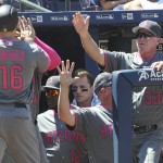 Arizona Diamondbacks' Chris Owings (16) enters the dugout as bench coach Glenn Sherlock (53) waits to congratulate him after he scored on a Patrick Corbin line drive triple to right field during the fifth inning of a baseball game against the Atlanta Braves, Sunday, May 8, 2016, in Atlanta. (AP Photo/John Amis)