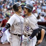 Colorado Rockies' Nolan Arenado (28) celebrates his two-run home run against the Arizona Diamondbacks with Carlos Gonzalez, left, during the seventh inning of a baseball game Sunday, May 1, 2016, in Phoenix. (AP Photo/Ross D. Franklin)