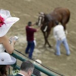 A fan watches a horse get ready for a race before the 142nd running of the Kentucky Derby horse race at Churchill Downs Saturday, May 7, 2016, in Louisville, Ky. (AP Photo/Charlie Riedel)