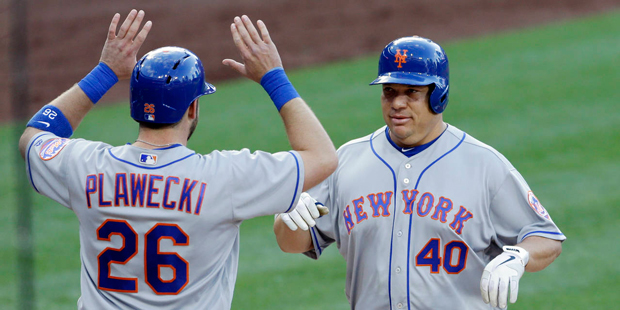 New York Mets' Bartolo Colon, right, is greeted by teammate Kevin Plawecki (26) after hitting a two...