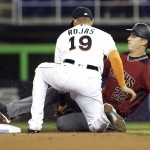 Arizona Diamondbacks' Jake Lamb (22) is tagged out by Miami Marlins second baseman Miguel Rojas (19) while stealing second during the first inning of a baseball game, Wednesday, May 4, 2016, in Miami. (AP Photo/Lynne Sladky)