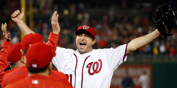 Washington Nationals starting pitcher Max Scherzer celebrates with his teammates after a baseball g...