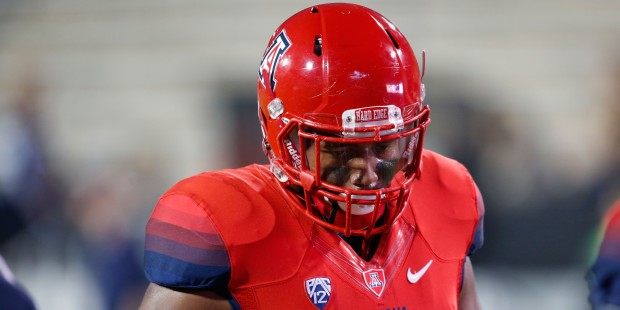 Arizona Wildcats defensive lineman Reggie Gilbert warms up before facing in the first half of an NC...