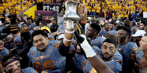 Arizona State players hold the Territorial Cup after an NCAA college football game against Arizona,...