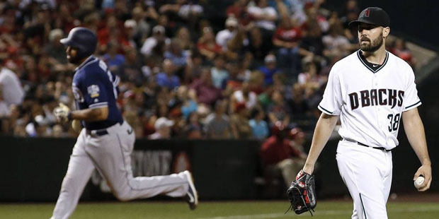 Arizona Diamondbacks' Robbie Ray (38) walks back to the mound with a new baseball after giving up a...