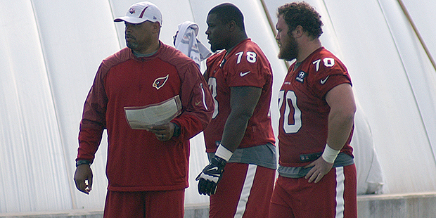 Offensive coordinator Harold Goodwin works with linemen Earl Watford and Evan Boehm during an OTA p...