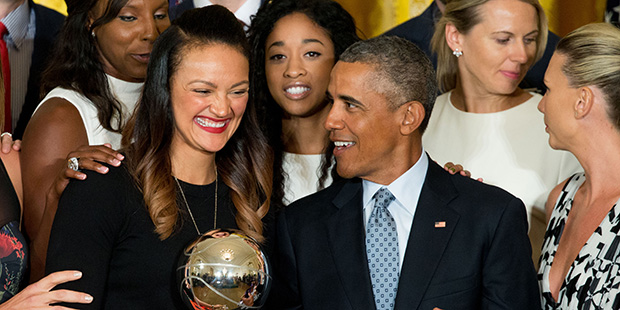 Phoenix Mercury forward Mistie Bass, center, laughs with President Barack Obama as she holds the WNBA Championship Trophy for a team photo in the East Room of the White House in Washington, Wednesday, Aug. 26, 2015, during a ceremony where the president honored the 2014 WNBA basketball Champions Phoenix Mercury. (AP Photo/Andrew Harnik)