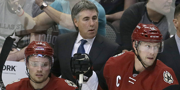 Arizona Coyotes coach Dave Tippett, center, stands behind center Max Domi (16) and right wing Shane...