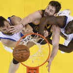 Cleveland Cavaliers forward Kevin Love, center, reaches for the ball between Golden State Warriors center Andrew Bogut, left, and forward Draymond Green during the first half of Game 2 of basketball's NBA Finals in Oakland, Calif., Thursday, June 2, 2016. (John G, Mabanglo, European Pressphoto Agency via AP, Pool)
