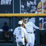 Miami right fielder Willie Abreu (13) catches a fly ball hit by Arizona's Louis Boyd, with Miami's Johnny Ruiz (4) watching, in the second inning of an NCAA men's College World Series baseball game in Omaha, Neb., Saturday, June 18, 2016. (AP Photo/Nati Harnik)