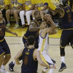Golden State Warriors guard Stephen Curry, center, shoots between Cleveland Cavaliers defenders during the first half of Game 2 of basketball's NBA Finals in Oakland, Calif., Sunday, June 5, 2016. (AP Photo/Marcio Jose Sanchez)
