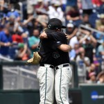 Coastal Carolina pitcher Andrew Beckwith, right, hugs Cole Schaefer after being relieved against Arizona in the sixth inning in Game 3 of the NCAA College World Series baseball finals in Omaha, Neb., Thursday, June 30, 2016. (AP Photo/Ted Kirk)