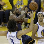 Cleveland Cavaliers guard Kyrie Irving, center, shoots against Golden State Warriors forward Anderson Varejao, bottom, and guard Shaun Livingston (34) during the second half of Game 1 of basketball's NBA Finals in Oakland, Calif., Thursday, June 2, 2016. (AP Photo/Marcio Jose Sanchez)