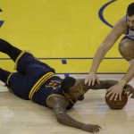 Cleveland Cavaliers guard J.R. Smith, left, reaches for a loose ball under Golden State Warriors center Andrew Bogut during the first half of Game 1 of basketball's NBA Finals in Oakland, Calif., Thursday, June 2, 2016. (AP Photo/Ben Margot)