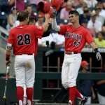 Arizona's Jared Oliva, right, is congratulated by teammate Kyle Lewis after hitting a two-run home run during the third inning of an NCAA College World Series baseball game against UC Santa Barbara, Wednesday, June 22, 2016, in Omaha, Neb. (AP Photo/Ted Kirk)