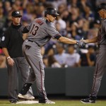 Arizona Diamondbacks' Nick Ahmed, left, is congratulated by first base coach Dave McKay after Ahmed hit an RBI-single to drive in the go-ahead run off Colorado Rockies relief pitcher Carlos Estevez in the ninth inning of a baseball game Thursday, June 23, 2016, in Denver. The Diamondbacks won 7-6. (AP Photo/David Zalubowski)