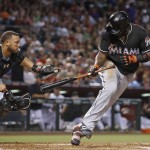 Arizona Diamondbacks' Welington Castillo, left, chases down Miami Marlins' Marcell Ozuna after Ozuna struck out but Castillo dropped the ball during the sixth inning of a baseball game Friday, June 10, 2016, in Phoenix. Ozuna was out on the play. The Marlins defeated the Diamondbacks 8-6. (AP Photo/Ross D. Franklin)
