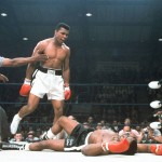 FILE - In this May 25, 1965, file photo, heavyweight champion Muhammad Ali is held back by referee Joe Walcott, left, after Ali knocked out challenger Sonny Liston in the first round of their title fight in Lewiston, Maine.  Ali, the magnificent heavyweight champion whose fast fists and irrepressible personality transcended sports and captivated the world, has died according to a statement released by his family Friday, June 3, 2016. He was 74. (AP Photo/File)