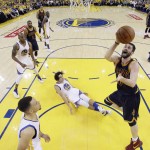 Cleveland Cavaliers' Kevin Love (0) gets a shot past Golden State Warriors' Anderson Varejao, bottom center, and Stephen Curry, bottom left, during the first half in Game 1 of basketball's NBA Finals Thursday, June 2, 2016, in Oakland, Calif. (AP Photo/Marcio Jose Sanchez, Pool)