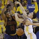 Golden State Warriors guard Klay Thompson, right, loses the ball as he is guarded by Cleveland Cavaliers center Tristan Thompson (13) and guard Kyrie Irving during the second half of Game 1 of basketball's NBA Finals in Oakland, Calif., Thursday, June 2, 2016. (AP Photo/Marcio Jose Sanchez)