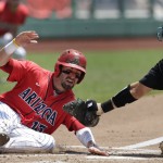 Arizona's Cody Ramer (13) is tagged out at home plate by Coastal Carolina catcher David Parrett (12) in the third inning in Game 3 of the NCAA College World Series baseball finals in Omaha, Neb., Thursday, June 30, 2016. (AP Photo/Nati Harnik)