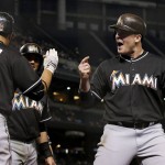 Miami Marlins' Justin Bour, right, celebrates his grand slam against the Arizona Diamondbacks with Martin Prado (14) and Miguel Rojas, rear, during the seventh inning of a baseball game Friday, June 10, 2016, in Phoenix. (AP Photo/Ross D. Franklin)