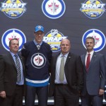 Logan Stanley, third from left, stands with members of the Winnipeg Jets management team and others at the NHL draft in Buffalo, N.Y., Friday June 24, 2016. (Nathan Denette/The Canadian Press via AP) MANDATORY CREDIT