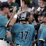 Coastal Carolina's Billy Cooke (17) celebrates with teammates after scoring on a Anthony Marks two-run single against Arizona in the third inning in Game 2 of the NCAA Men's College World Series finals baseball game in Omaha, Neb., Tuesday, June 28, 2016. (AP Photo/Nati Harnik)