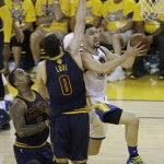 Golden State Warriors guard Klay Thompson, right, shoots against Cleveland Cavaliers forward Kevin Love (0) and guard J.R. Smith (5) during the first half of Game 2 of basketball's NBA Finals in Oakland, Calif., Sunday, June 5, 2016. (AP Photo/Marcio Jose Sanchez)