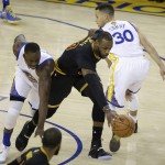 Cleveland Cavaliers forward LeBron James, center, dribbles between Golden State Warriors forward Draymond Green, left, and guard Stephen Curry (30) during the first half of Game 7 of basketball's NBA Finals in Oakland, Calif., Sunday, June 19, 2016. (AP Photo/Eric Risberg)