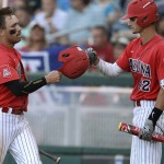 Arizona's Zach Gibbons, left, celebrates with Jared Oliva (42) after scoring a Bobby Dalbec single against Coastal Carolina in the first inning in Game 2 of the NCAA Men's College World Series finals baseball game in Omaha, Neb., Tuesday, June 28, 2016. (AP Photo/Nati Harnik)