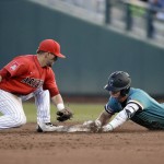 Coastal Carolina's Kevin Woodall Jr. (19) slides into second base for a double ahead of the tag of Arizona second baseman Cody Ramer in the fifth inning in Game 2 of the NCAA Men's College World Series finals baseball game in Omaha, Neb., Tuesday, June 28, 2016. (AP Photo/Nati Harnik)