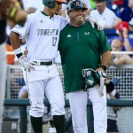 Miami's Christopher Barr (17) puts his arm around first base coach Norberto Lopez after hitting a single that scored Brandon Lopez in the fourth inning of an NCAA men's College World Series baseball game against Arizona in Omaha, Neb., Saturday, June 18, 2016. (AP Photo/Nati Harnik)