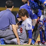 Los Angeles Dodgers' Kenta Maeda grimaces as he tries to get up off the ground as Dodgers players and staff attend to him during the sixth inning of a baseball game against the Arizona Diamondbacks on Tuesday, June 14, 2016, in Phoenix. Maeda was struck on the right leg from a ball hit by Diamondbacks' Paul Goldschmidt. (AP Photo/Ross D. Franklin)