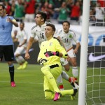 Mexico's Hector Herrera (16) and Javier Hernandez (14) celebrate Herrera's goal as Uruguay's Fernando Muslera, front middle, and Diego Godin (3) show their frustration during the first half of a Copa America soccer match at University of Phoenix Stadium Sunday, June 5, 2016, in Glendale, Ariz. (AP Photo/Ross D. Franklin)