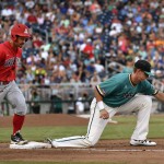 Coastal Carolina first baseman Kevin Woodall Jr., right, catches the throw for an out on Arizona's Louis Boyd in the fourth inning in Game 1 of the NCAA Men's College World Series finals baseball game in Omaha, Neb., Monday, June 27, 2016. (AP Photo/Ted Kirk)
