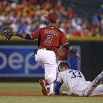 Los Angeles Dodgers' Scott Van Slyke (33) slides safely into second base with a double as Arizona Diamondbacks' Jean Segura (2) is unable to catch the baseball during the fourth inning of a baseball game Wednesday, June 15, 2016, in Phoenix. (AP Photo/Ross D. Franklin)
