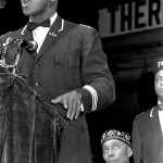 FILE - In this Feb. 25, 1968, file photo, former heavyweight boxing champion Muhammad Ali speaks at a Black Muslim convention in Chicago. Seated behind Ali is Elijah Muhammad, leader of the Nation of Islam. Ali, the magnificent heavyweight champion whose fast fists and irrepressible personality transcended sports and captivated the world, has died according to a statement released by his family Friday, June 3, 2016. He was 74. (AP Photo/file)
