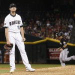 Arizona Diamondbacks' Tyler Clippard, left, pauses on the mound after giving up a grand slam to Miami Marlins' Justin Bour, right, during the seventh inning of a baseball game Friday, June 10, 2016, in Phoenix. (AP Photo/Ross D. Franklin)