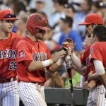 Arizona's Cody Ramer celebrates with teammates after scoring on a Ryan Aguilar fielders choice against Coastal Carolina in the fifth inning in Game 2 of the NCAA Men's College World Series finals baseball game in Omaha, Neb., Tuesday, June 28, 2016. (AP Photo/Nati Harnik)
