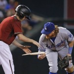 Los Angeles Dodgers' Justin Turner, right, hands a off a piece of broken bat, from an Arizona Diamondbacks' Brandon Drury pop fly out, to the Diamondbacks' bat boy during the first inning of a baseball game Wednesday, June 15, 2016, in Phoenix. (AP Photo/Ross D. Franklin)