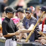Miami Marlins' Ichiro Suzuki, of Japan, returns a bat to a fan after autographing it prior to a baseball game against the Arizona Diamondbacks, Sunday, June 12, 2016, in Phoenix. (AP Photo/Ross D. Franklin)