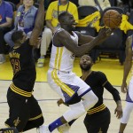 Golden State Warriors forward Draymond Green, center, shoots between Cleveland Cavaliers center Tristan Thompson (13) and guard Mo Williams during the first half of Game 7 of basketball's NBA Finals in Oakland, Calif., Sunday, June 19, 2016. (AP Photo/Marcio Jose Sanchez)