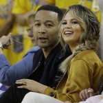 Musician John Legend, left, and his wife Chrissy Teigen watch during the first half of Game 1 of basketball's NBA Finals between the Golden State Warriors and the Cleveland Cavaliers in Oakland, Calif., Thursday, June 2, 2016. (AP Photo/Marcio Jose Sanchez)
