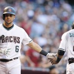 Arizona Diamondbacks' Jean Segura (2) slaps hands with David Peralta (6) after Segura scored a run against the Los Angeles Dodgers during the first inning of a baseball game Tuesday, June 14, 2016, in Phoenix. (AP Photo/Ross D. Franklin)