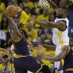Cleveland Cavaliers forward LeBron James, left, looks to pass as Golden State Warriors center Festus Ezeli defends during the first half of Game 1 of basketball's NBA Finals in Oakland, Calif., Thursday, June 2, 2016. (AP Photo/Marcio Jose Sanchez)